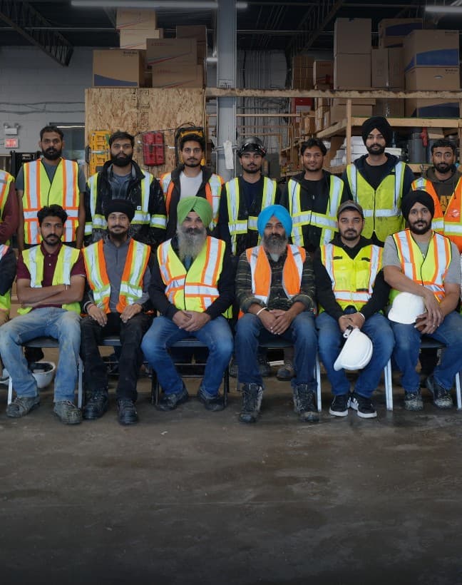 The Group 3 Plumbing crew at the shop, with Gursharan and Gursewak Singh Grewal in the front row